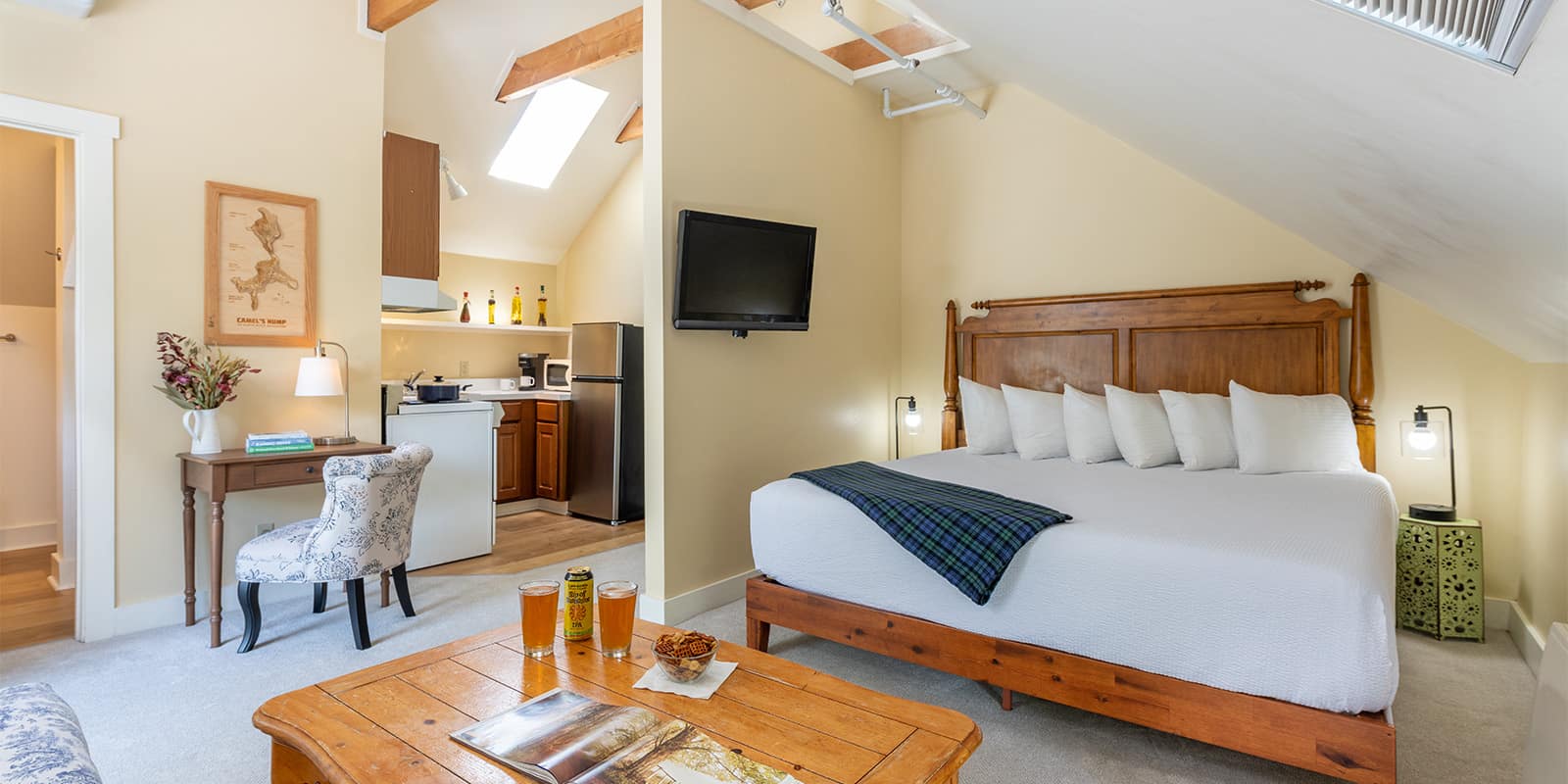 King bed in our Vermont Romantic Getaway with efficiency kitchen in the backgroud