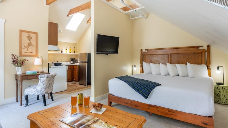 King bed in our Vermont Romantic Getaway with efficiency kitchen in the backgroud